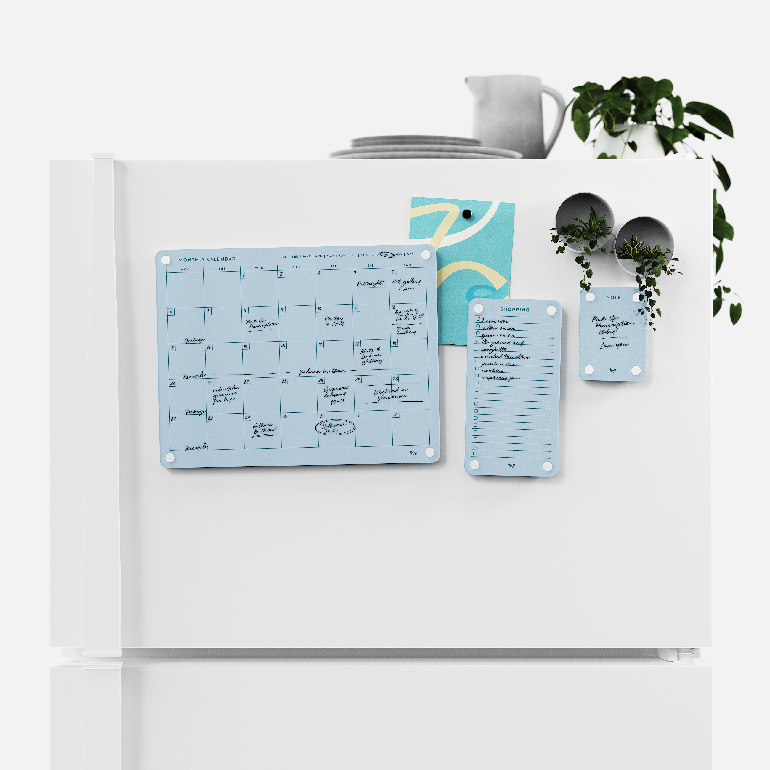 Vista blue monthly calendar, shopping list and note board magnetised to a white fridge door